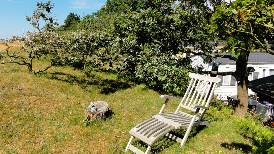Ligstoel op een zandwal bij een stacaravan op camping Kotestee in Ouddorp.