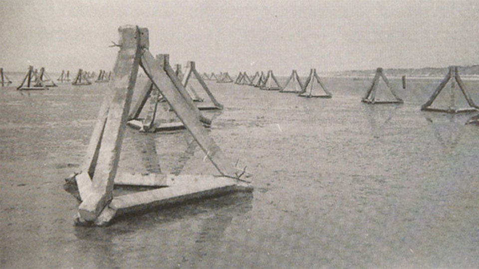 Een serie taetreder palen op het strand om de geallieerden tegen te houden