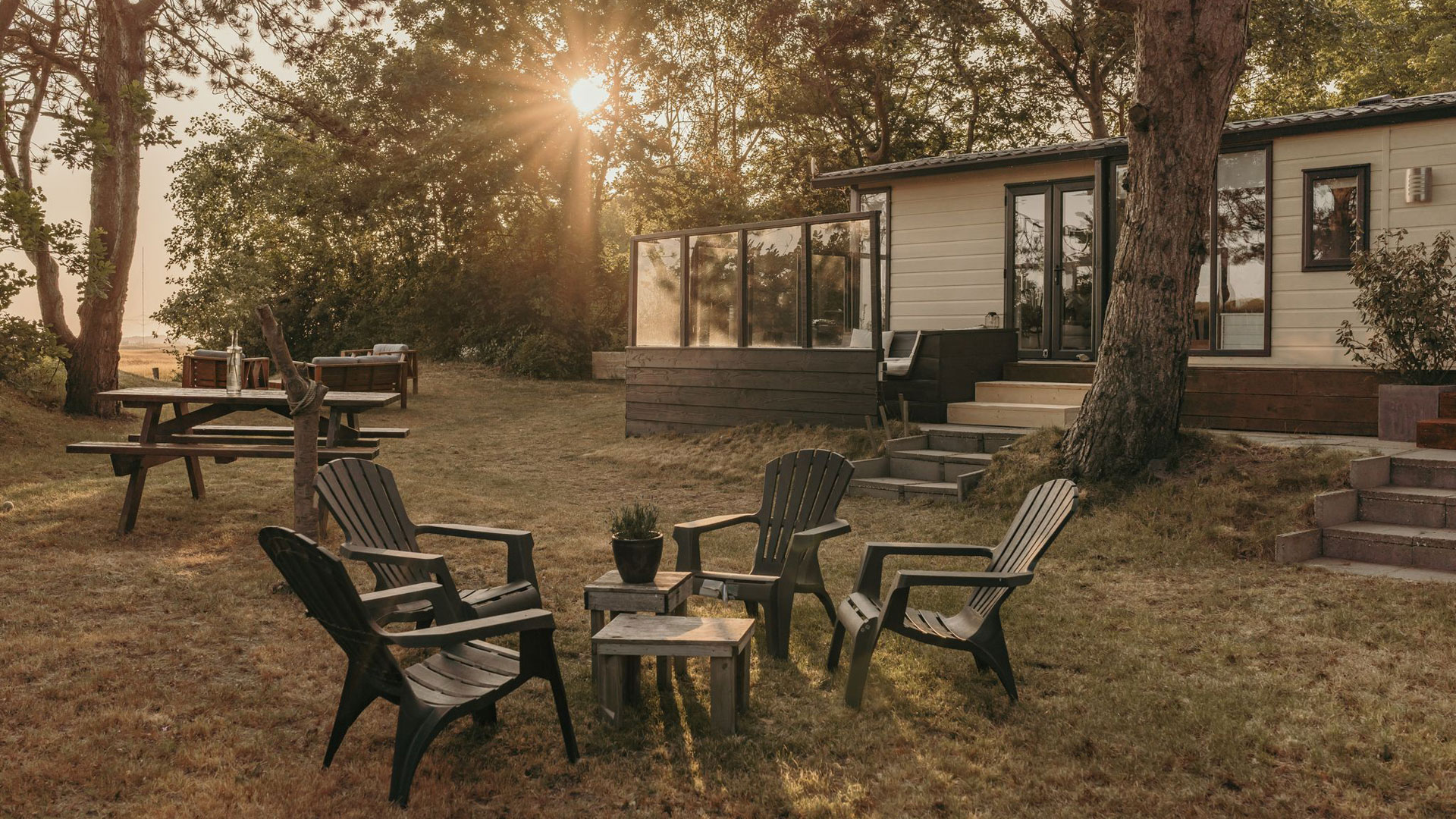 Zitje bij luxe chalet op camping in Ouddorp met zonsondergang